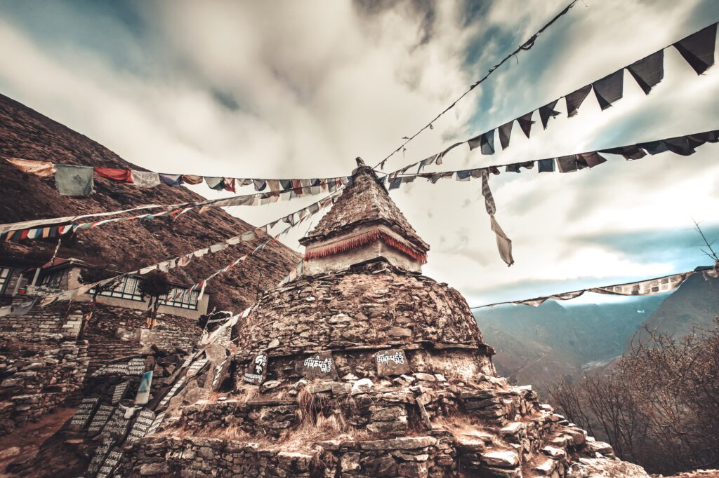 Prayer flags and buddhist stupa on trekking route