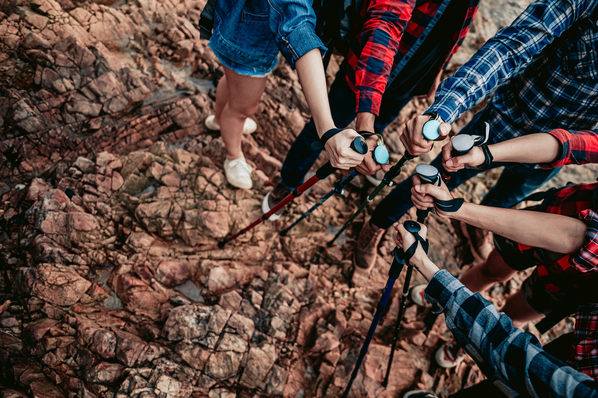 A group of hikers holding trekking sticks join together as a team.Teamwork , travel trekking